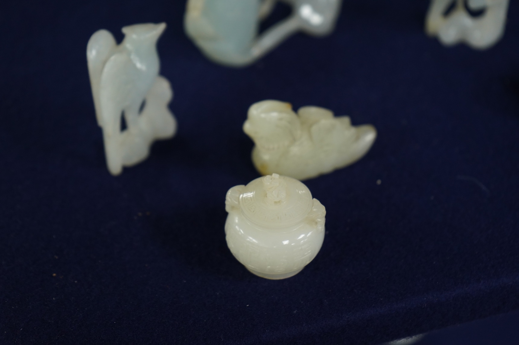 A Chinese jade figure of a Mandarin duck and a miniature pot and cover, three jadeite carvings and a bowenite dragon, 16.5cm